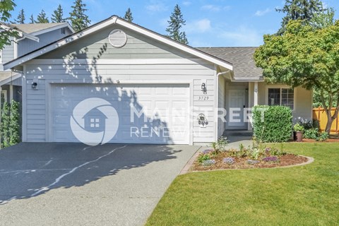 a home with a white garage door and a lawn